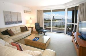 a living room with a couch and a television with a balcony at Ocean Sands Resort in Gold Coast