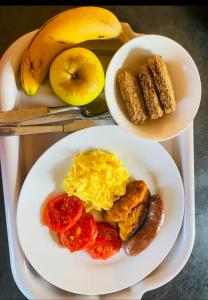 een bord ontbijtproducten met eieren, worst en tomaten bij SUNFLOWER bed and breakfast in Ladysmith