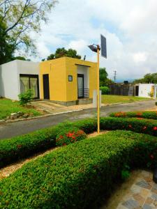 a yellow building with a flag on the side of a road at Casa Vacacional - Portales del Sol 2 in Tocaima