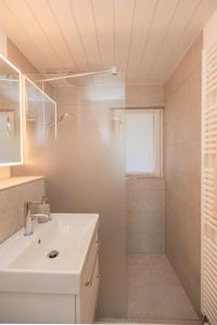 ein weißes Badezimmer mit Waschbecken und Dusche in der Unterkunft Mätzwiesen Höckli - CharmingStay in Flumserberg