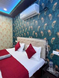 ein Schlafzimmer mit einem Bett mit roten und weißen Kissen in der Unterkunft The Yash Residency in Ayodhya