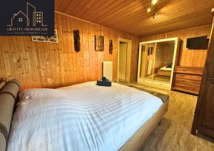 een slaapkamer met een groot bed in een houten kamer bij Spacious duplex with garden - Marignier in Marignier