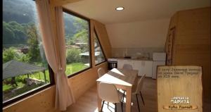 a kitchen with a table and a large window at Kuca Rancic in Pirot