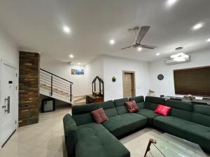 a living room with a green couch and a staircase at The Elegant 3BedRoom Home in Community 25, Tema in Dawhwenya