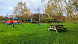 - une table de pique-nique et une aire de jeux dans un champ dans l'établissement Gîte Le 47, à Levernois