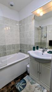 une salle de bain avec une baignoire, un lavabo et des toilettes dans l'établissement Gîte Le 47, à Levernois