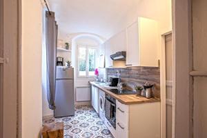 a kitchen with white cabinets and a refrigerator at Casa Rione in Omessa