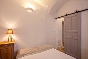 a bedroom with a bed and a lamp and a door at Casa Rione in Omessa