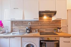 a kitchen with white cabinets and a sink at Casa Rione in Omessa