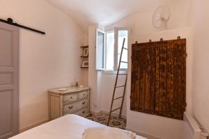 a bedroom with a ladder next to a dresser and a window at Casa Rione in Omessa +12 photos