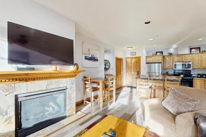 a living room with a fireplace and a flat screen tv at Main Street Station #2302 in Breckenridge