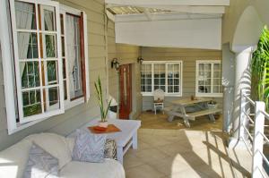 a porch with a couch and a table and windows at Knysna N2 Lodge in Knysna