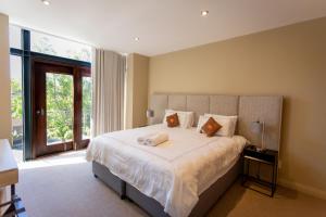 ein Schlafzimmer mit einem großen Bett mit einem großen Fenster in der Unterkunft Terrace Tranquility at Oubaai Golf Estate in Herolds Bay
