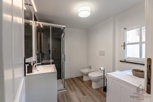 a white bathroom with a sink and a toilet at Historic Palace Duplex - Cruises 2min - AC - WiFi in Savona +23 photos