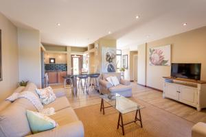 ein Wohnzimmer mit Sofa und Tisch in der Unterkunft Terrace Tranquility at Oubaai Golf Estate in Herolds Bay