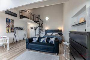 a living room with a couch and a spiral staircase at Historic Palace Duplex - Cruises 2min - AC - WiFi in Savona