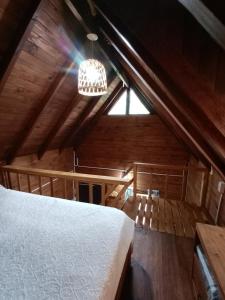 ティグレにあるTinyHouseLosAndesのベッドとシャンデリア付きの屋根裏部屋