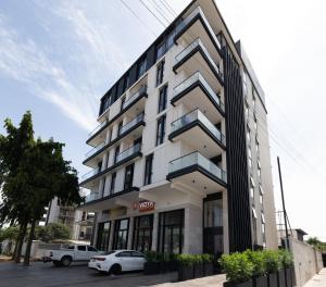 a white car parked in front of a building at Bluewaters, Labone in Accra
