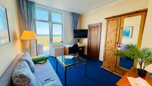 a living room with a couch and a table at "Sanddorn", Kur- und Ferienhotel, Direkte Strandlage, Fahrstuhl in Warnemünde +42 photos