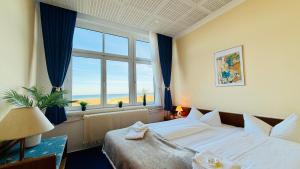 a hotel room with a bed and a large window at "Sanddorn", Kur- und Ferienhotel, Direkte Strandlage, Fahrstuhl in Warnemünde