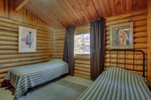 a bedroom with two beds in a log cabin at Walk to Lava Hot Springs Pools from Cozy Cabin! in Lava Hot Springs