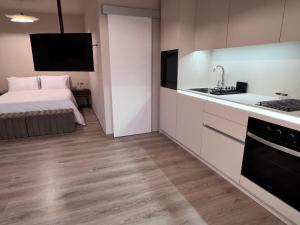 Un dormitorio con una cama y una cocina con fregadero. en Coffee apartamento, Las Galletas, en Arona 29 fotos más