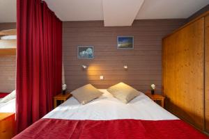 Un dormitorio con una cama con una cortina roja. en Village Vacances Le Tarbesou - Pied de piste station Ax 3 Domaines, en Ax-les-Thermes 29 fotos más
