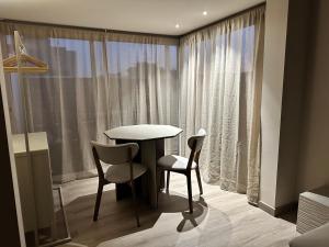 Una mesa y sillas en una habitación con ventana. en Coffee apartamento, Las Galletas, en Arona