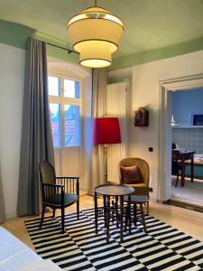 a living room with a table and chairs and a lamp at Schulze am Markt in Lichtenfels