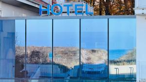 a reflection of a hotel sign in the windows of a building at "Sanddorn", Kur- und Ferienhotel, Direkte Strandlage, Fahrstuhl in Warnemünde