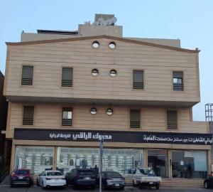 a building with cars parked in front of it at شقة بغرفتي نوم وغرفة معيشة in Jeddah