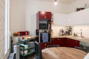 a kitchen with red cabinets and a table in it at Ideal stay in Puteaux with private courtyard in Puteaux