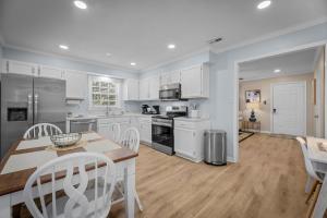 a kitchen with white cabinets and a table and chairs at Pet-Friendly 3 BR Home with King Bed and Fenced Yard Near Downtown in New Bern
