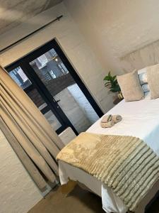 a bedroom with a bed and a large window at Serenity sleep in Johannesburg