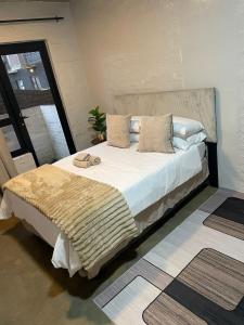 ein Schlafzimmer mit einem großen Bett mit zwei Hausschuhen darauf in der Unterkunft Serenity sleep in Johannesburg