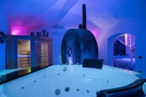 a large bath tub in a room with purple lights at Grotta azzurra - Suite e spa in Monticelli