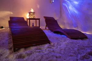 three wooden benches sitting in a room covered in snow at Grotta azzurra - Suite e spa in Monticelli