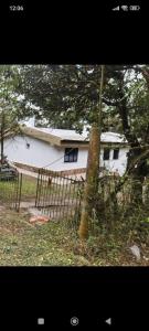 a white house with a tree in front of it at Davolio Hosting in Yerba Buena