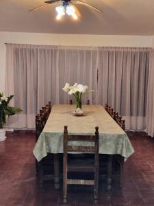 a dining room table with a vase of flowers on it at Davolio Hosting in Yerba Buena
