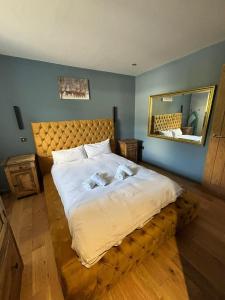 a large bed in a bedroom with a mirror at Luxurious, Unique & Elegant Cottage with Hot Tub in Ollach