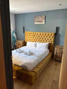 a bedroom with a large bed with a tufted headboard at Luxurious, Unique & Elegant Cottage with Hot Tub in Ollach +13 photos