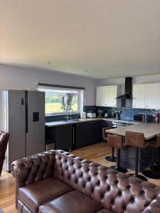 a living room with a couch in a kitchen at Luxurious, Unique & Elegant Cottage with Hot Tub in Ollach