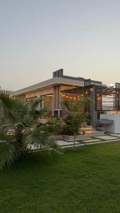 a large building with a palm tree in front of it at شاليه هوانا in Sohar