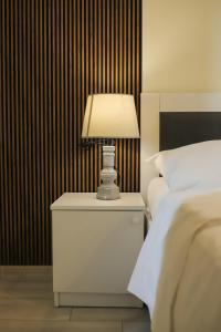 une lampe sur une table de nuit à côté d'un lit dans l'établissement Batumi Modern Deluxe Apartment, à Kakhaberi 32 autres photos