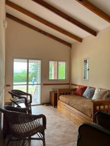 ein Wohnzimmer mit einem Bett und Stühlen in der Unterkunft Casa en Potrero de Garay in Potrero de Garay