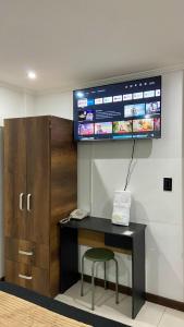 FunzaにあるHotel Funza Realの机と椅子、そして壁に掛けられたテレビ