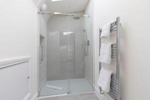 eine Dusche mit Glastür im Badezimmer in der Unterkunft Elliot Oliver - Stunning 4 Bedroom Home with Parking in Cheltenham in Cheltenham + 19 Fotos