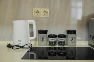un comptoir avec quatre tasses à café sur un comptoir dans l'établissement Batumi Modern Deluxe Apartment, à Kakhaberi