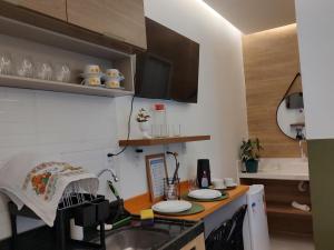 a kitchen with a sink and a counter with plates on it at Studio 101 Cop 30 in Belém