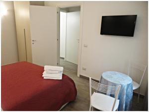 ein Zimmer mit einem Bett, einem Tisch und einem Fernseher in der Unterkunft LunaBlù in Rom